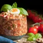 Jar of Tomato Basil Overnight Oats topped with fresh basil leaves