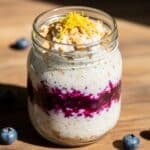 Blueberry cheesecake gelatin oats layered in a serving jar