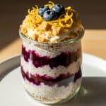 Blueberry cheesecake gelatin oats layered in a serving jar